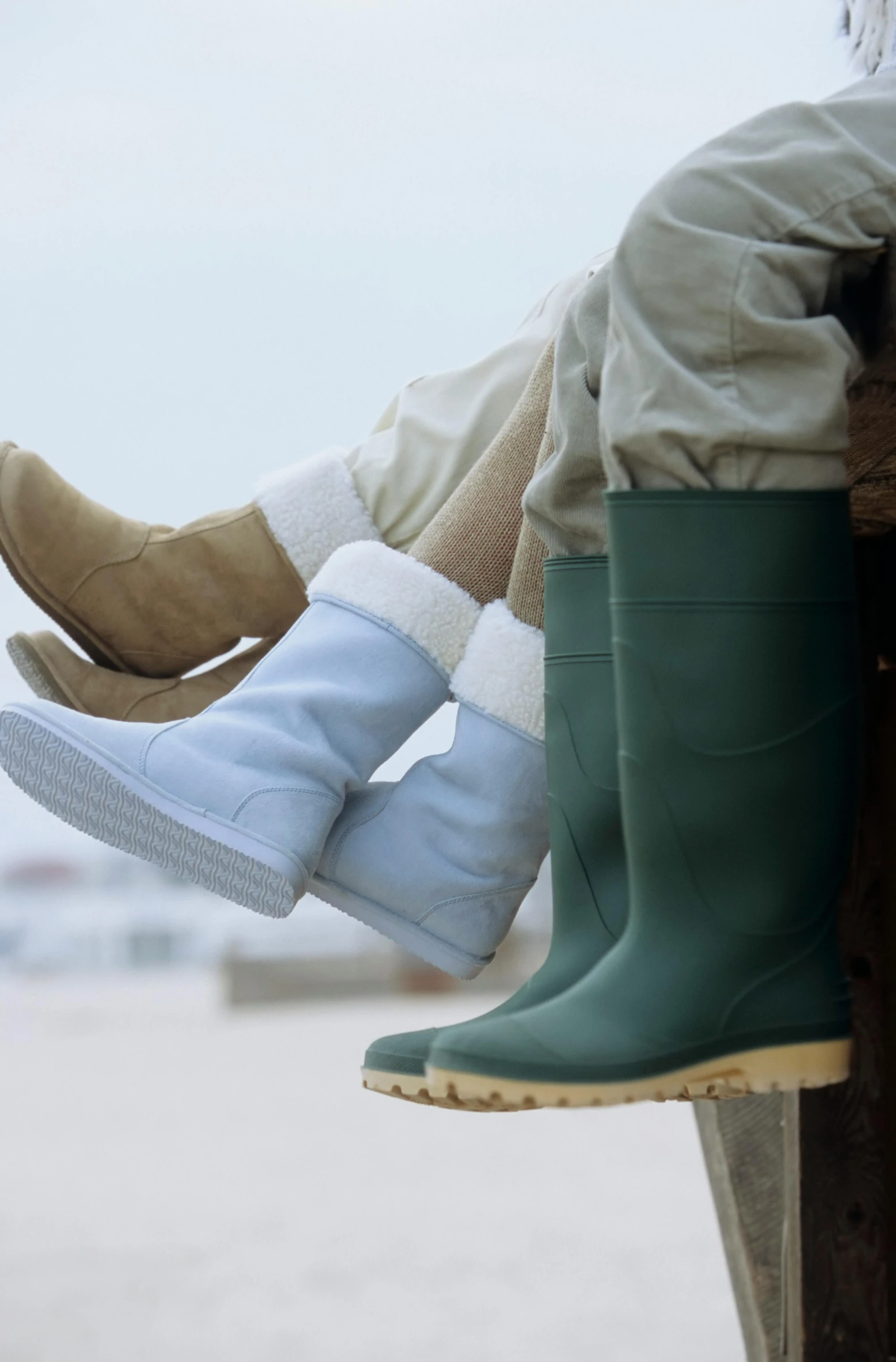 a pair of well used boots, including waterproof boots, are sitting on a piece of wood