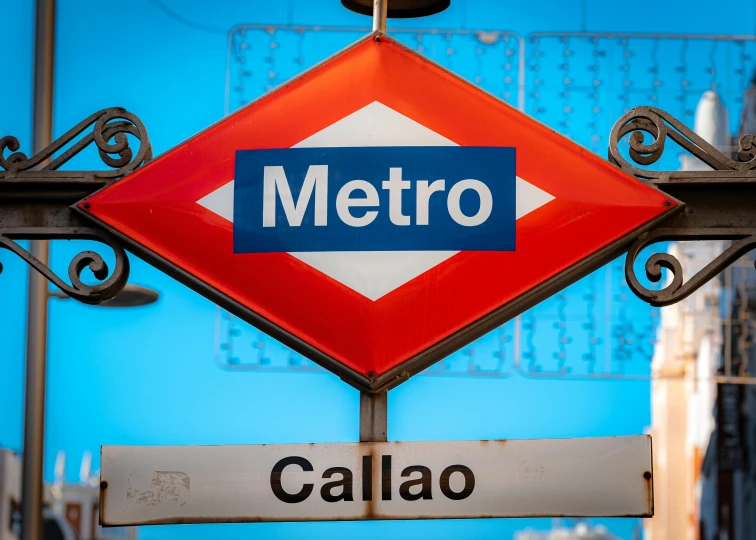 street sign hanging from a pole that reads metro callao