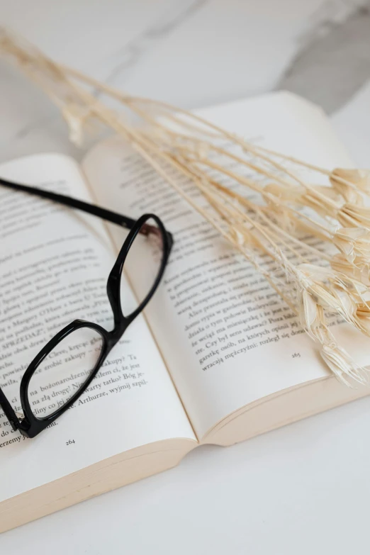 a close up of a book with glasses sitting on top