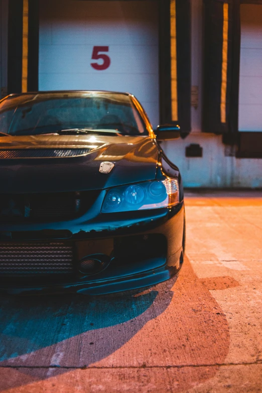 the front of a black sports car parked outside of a store