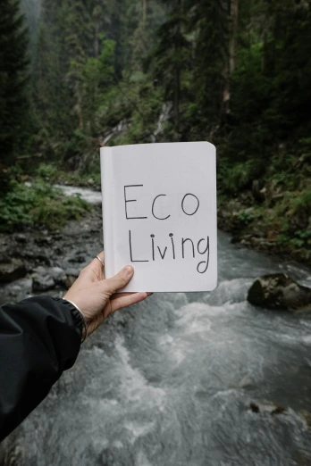 person holding up a sign that says eco living
