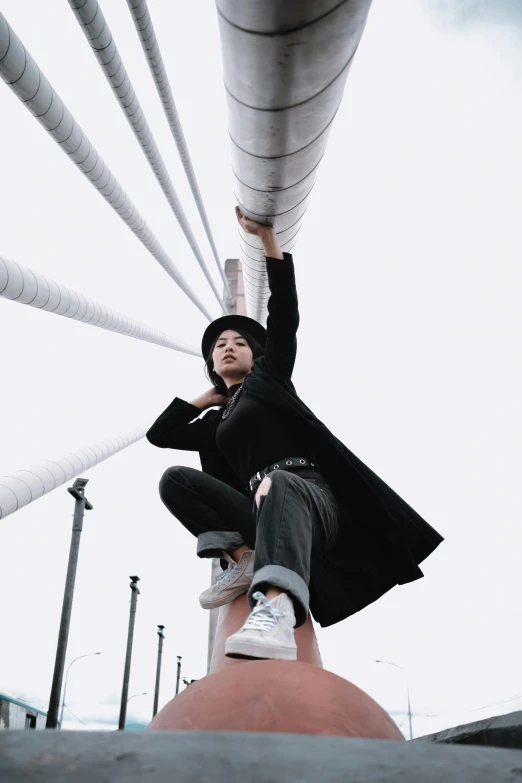 a woman in a long jacket on a pole