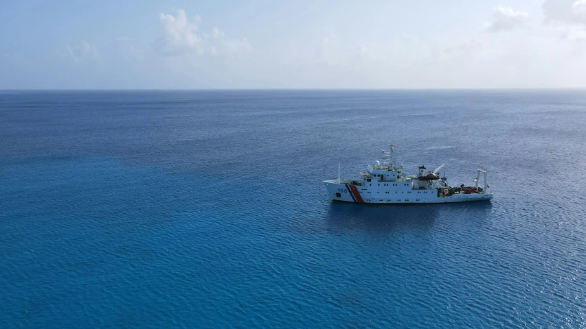 an empty boat floating across the blue ocean