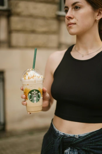 a woman holding a starbucks drink on her left arm