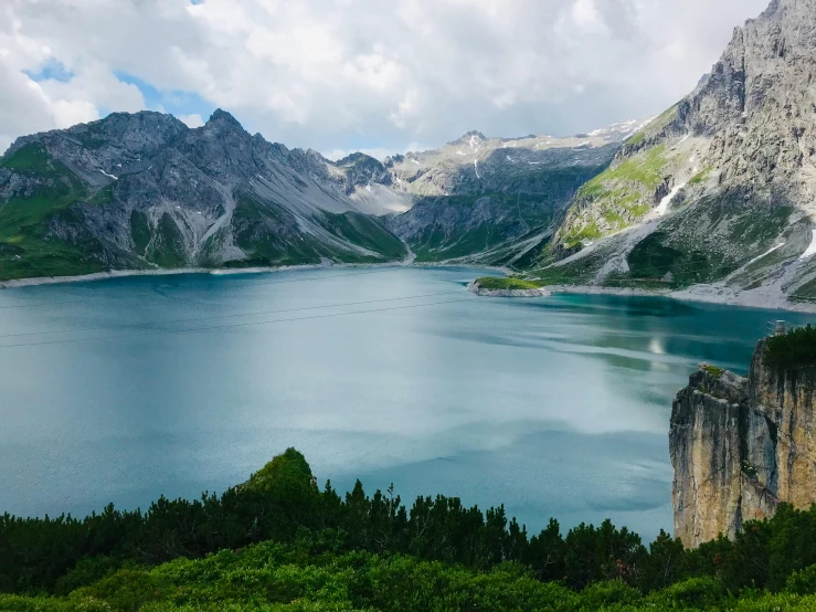 blue water and mountain in alpine region with cloudy sky