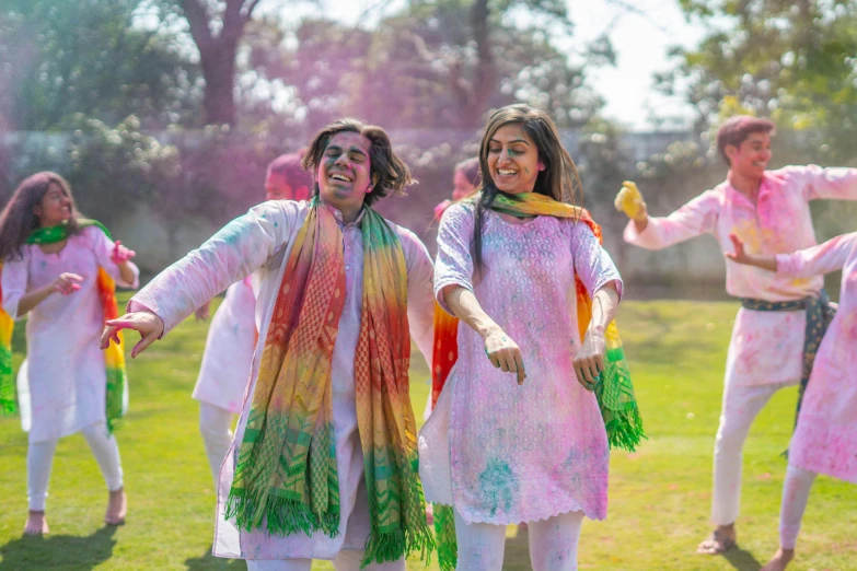 four people standing on a green field together