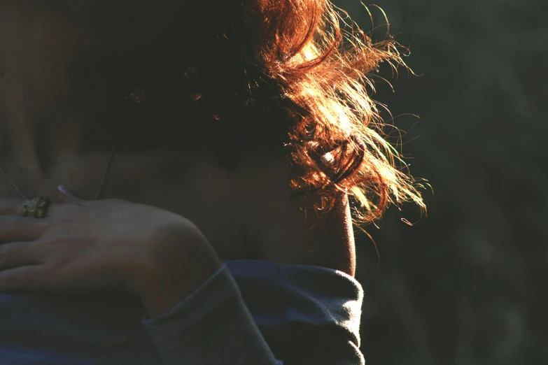 an image of the back of a girl's neck with her hands on her chest