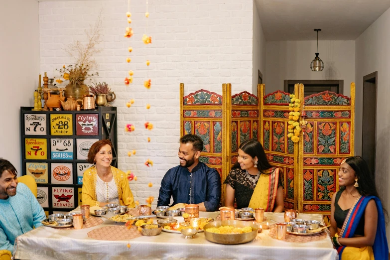 a group of people sitting around a table full of food