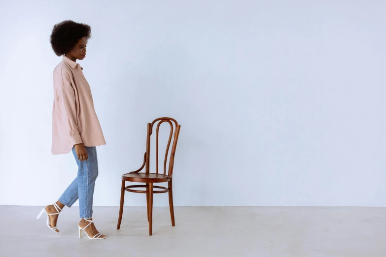 a woman standing in front of a chair with one foot on the floor