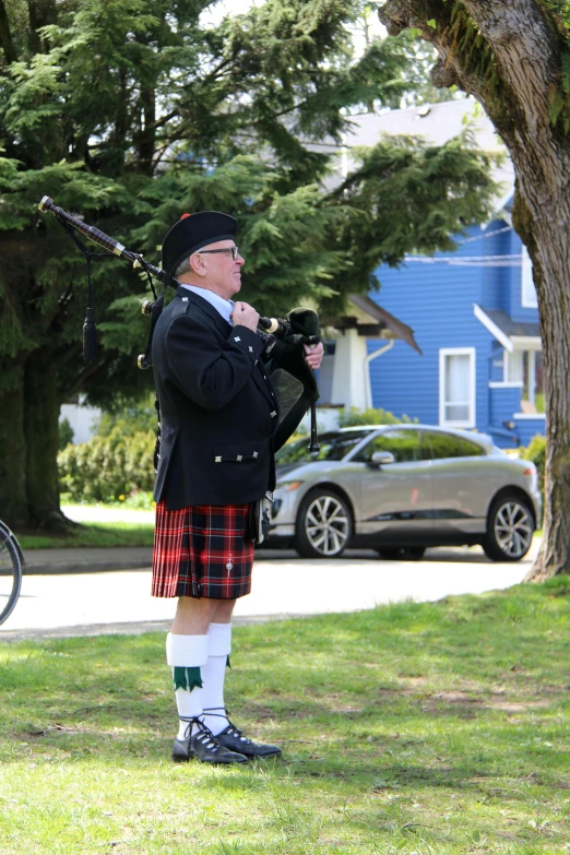 a man in a scottish kilt plays the bagpipe