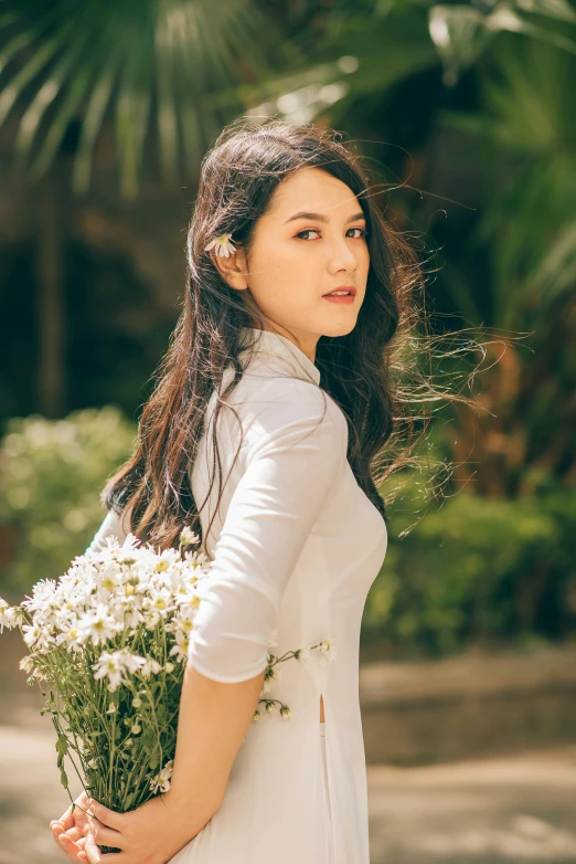 a woman standing outside with a bouquet of flowers