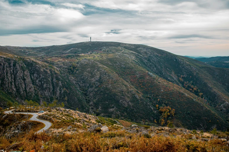 a mountain view shows a scenic road surrounded by forest