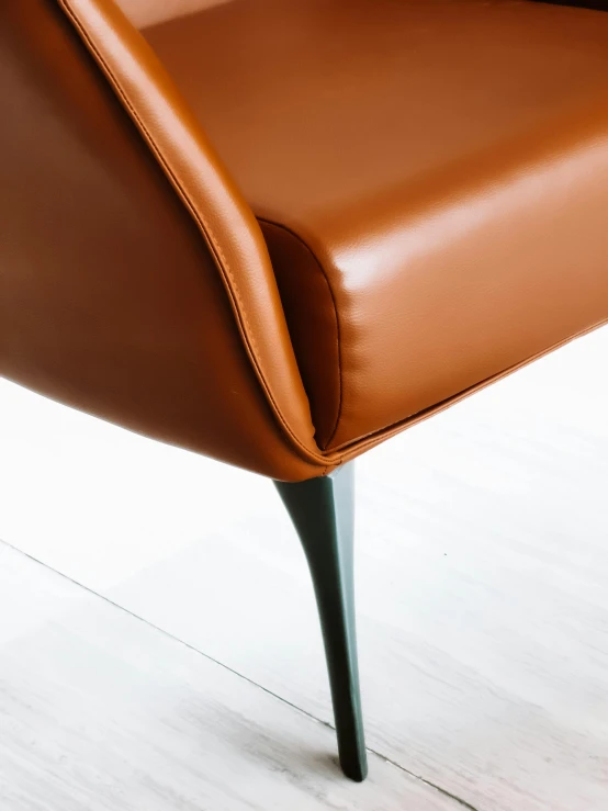 brown leather chair with metal legs on a hard wood floor