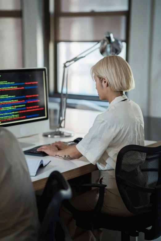 a woman sitting in front of a computer working