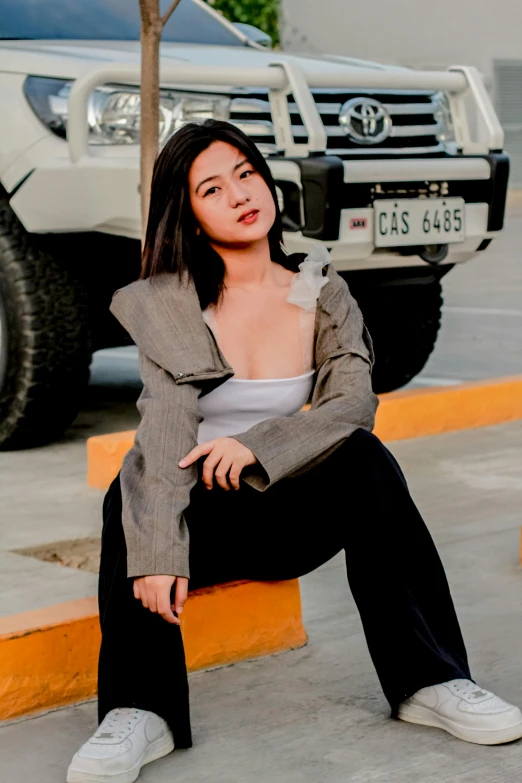 woman wearing a suit sitting on the back of a pickup truck