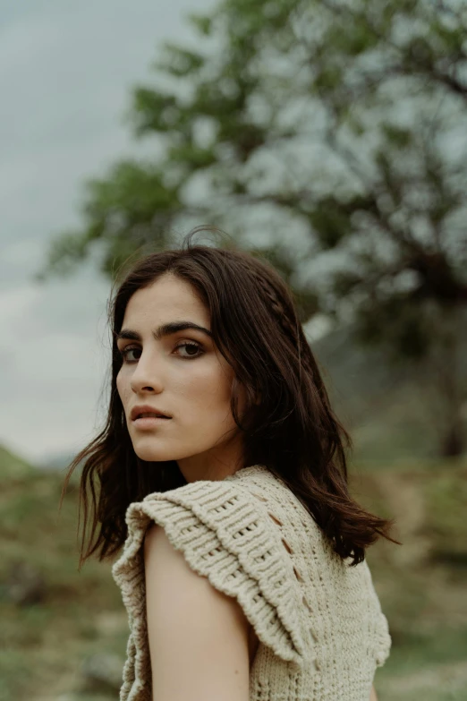 the girl poses for a po by a tree