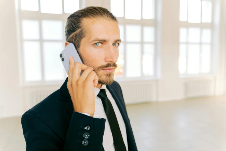 a man in business clothes is talking on a cell phone
