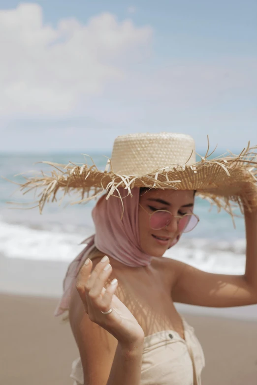 woman in straw hat walking at the beach