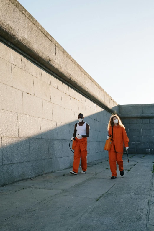 a couple of men are walking down a sidewalk