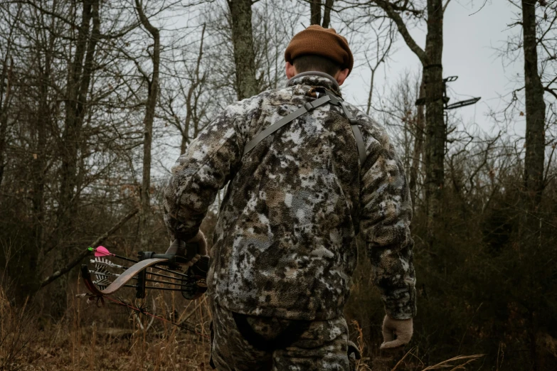 a man in a hunting outfit holding a bicycle