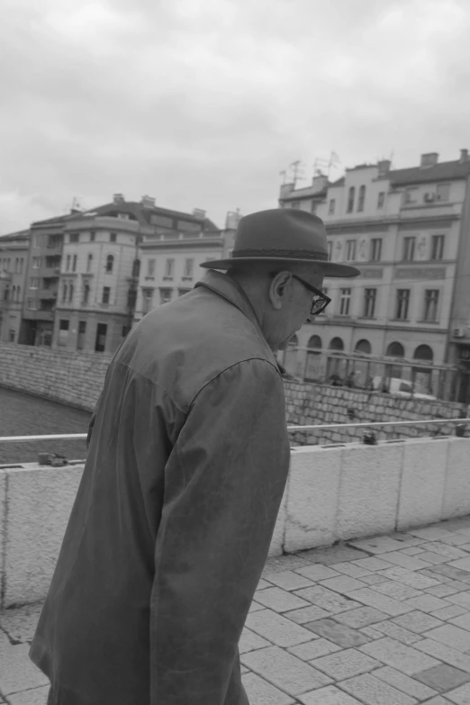 a man on the sidewalk with luggage and buildings in background