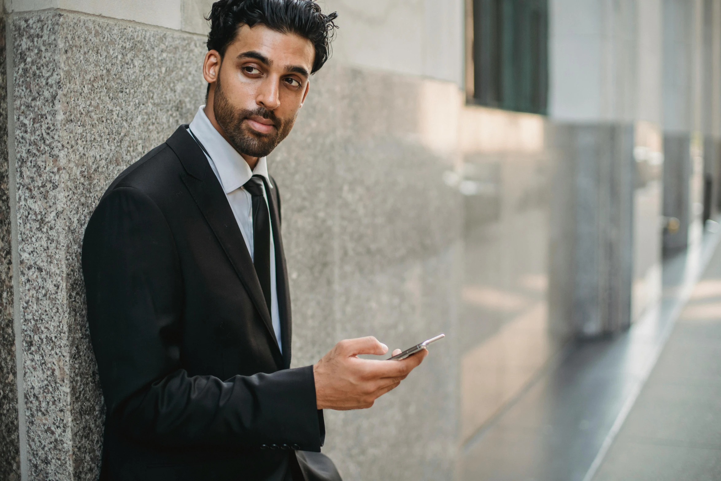 a businessman leaning against the wall in an office building