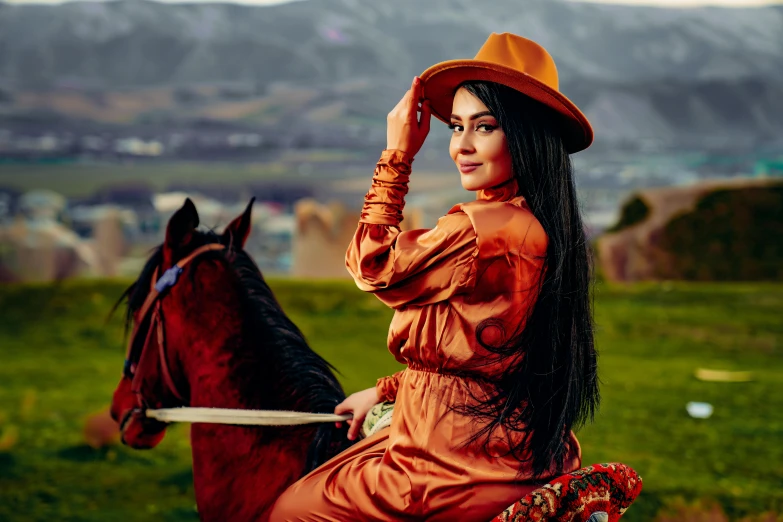 a woman wearing an orange top is sitting on a horse