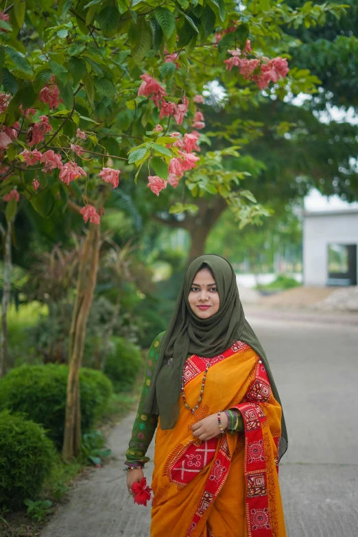 a woman is standing next to a tree