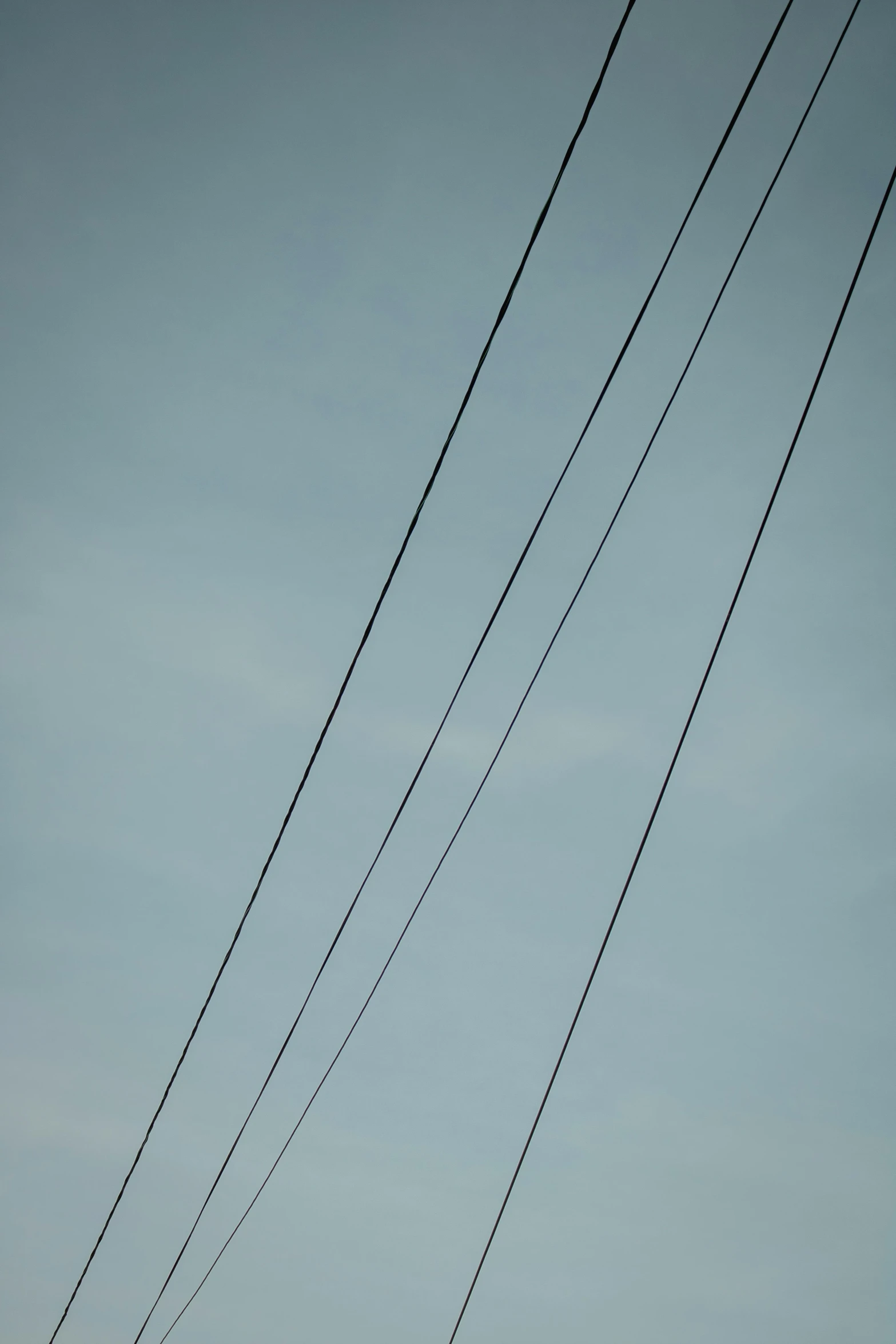 the sky is very gray today but that has an old telephone pole