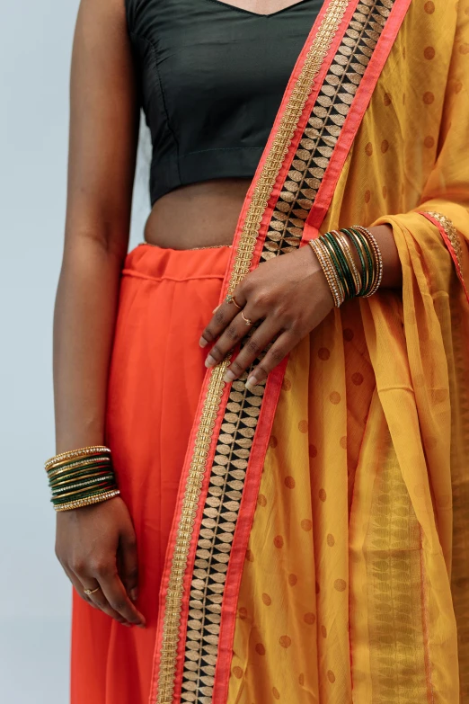 a woman in orange and yellow clothes is wearing rings