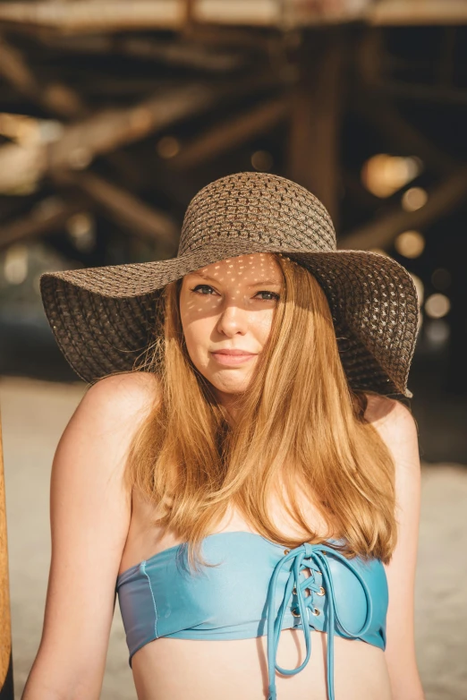 a girl is in a bikini and hat