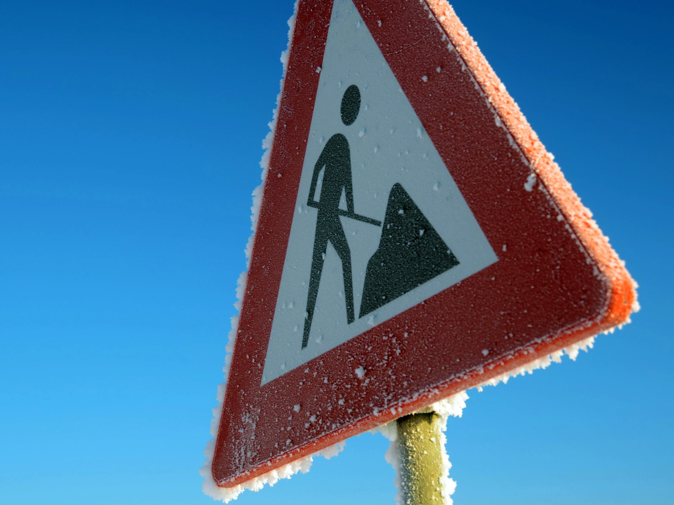 snow on the roof of a street sign