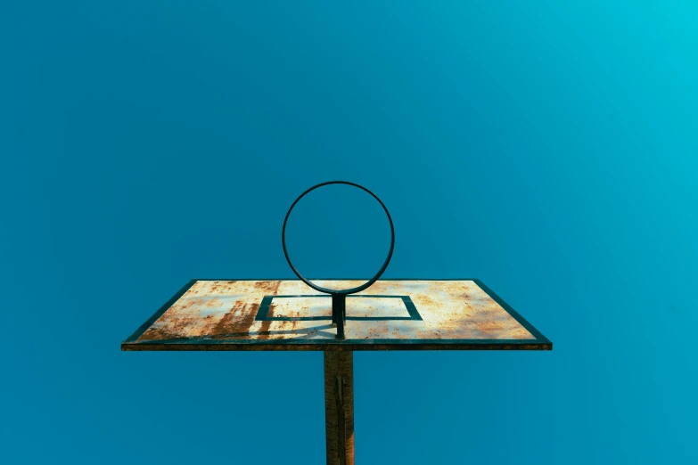 a rusty sign has a magnifying glass on top