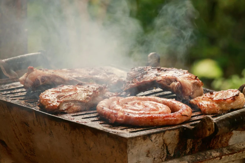 grilled meat on a bbq with lots of smoke