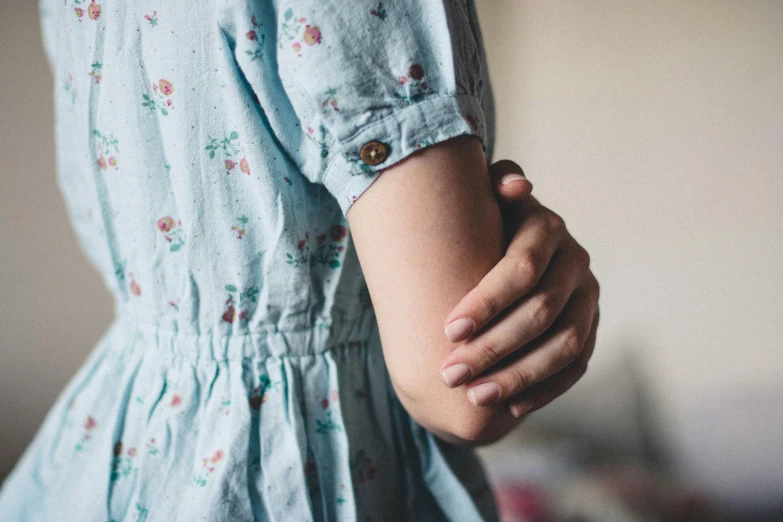 the hand of a child holding it's arm