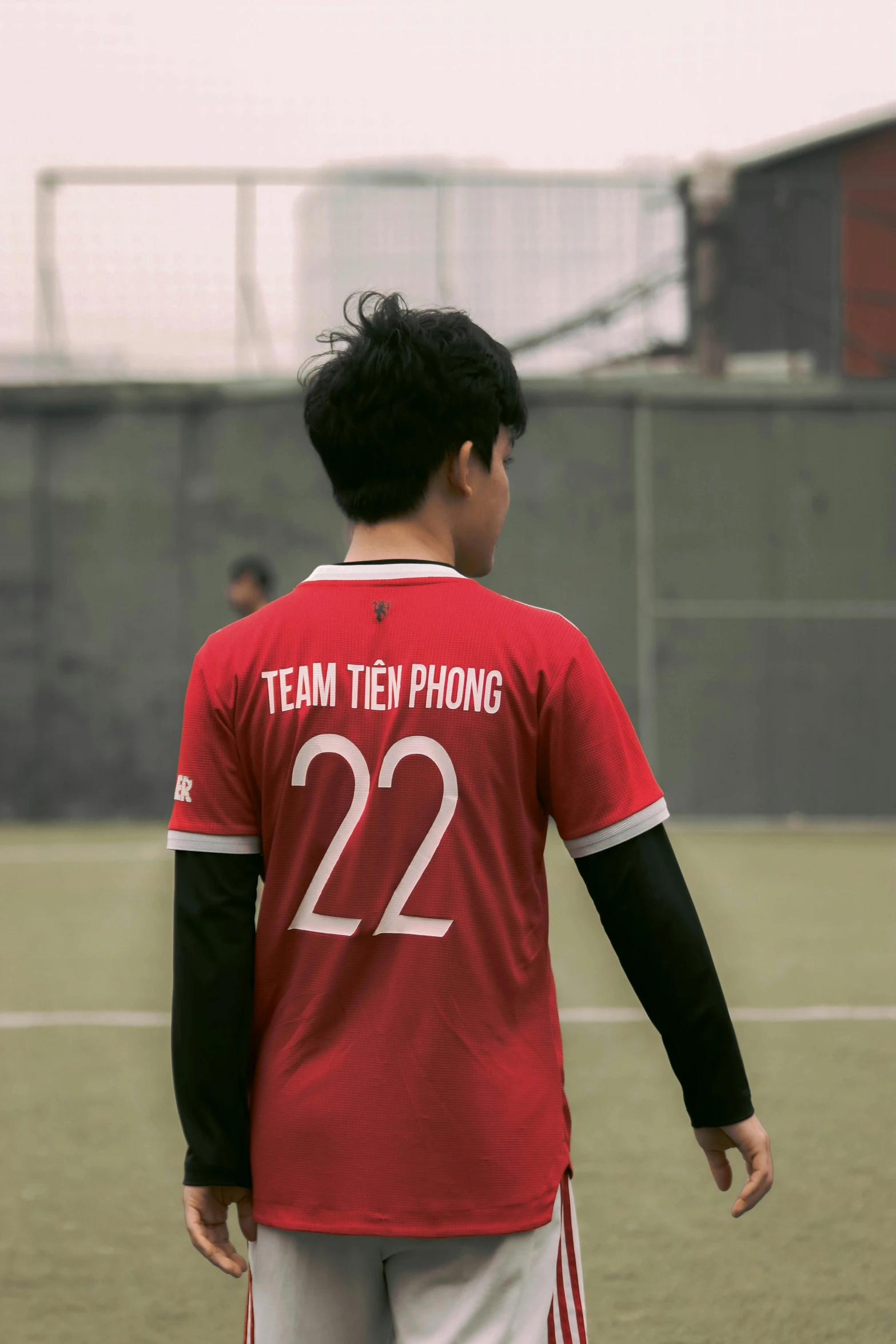 a person with a soccer shirt standing on the field