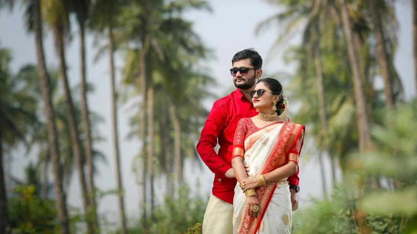 two indian people pose for a picture during their wedding