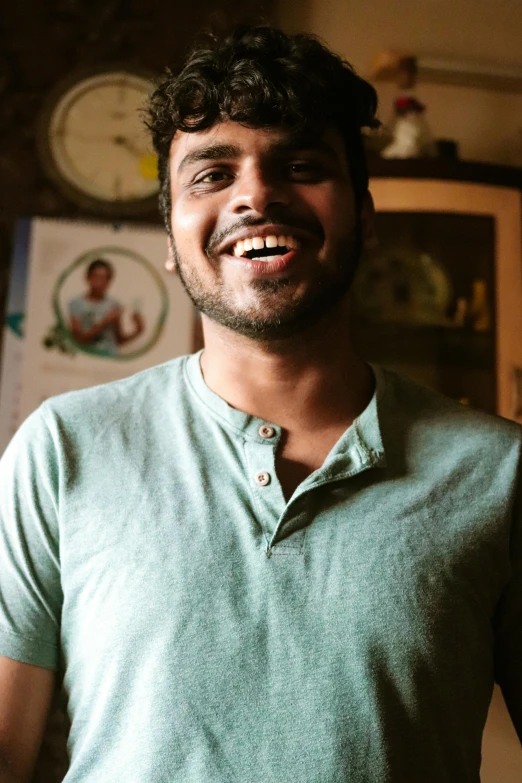 a man wearing a mint green polo shirt with curly hair