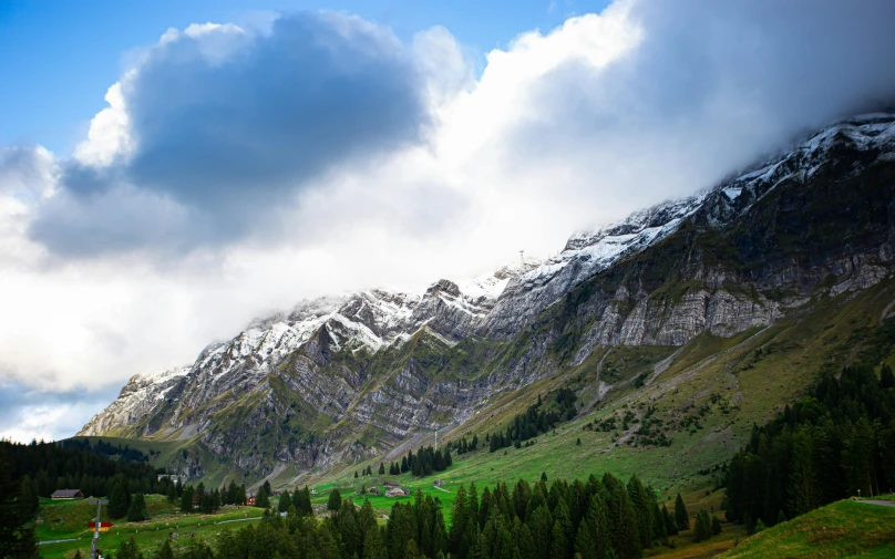 a landscape view of the mountains, green grass and mountains