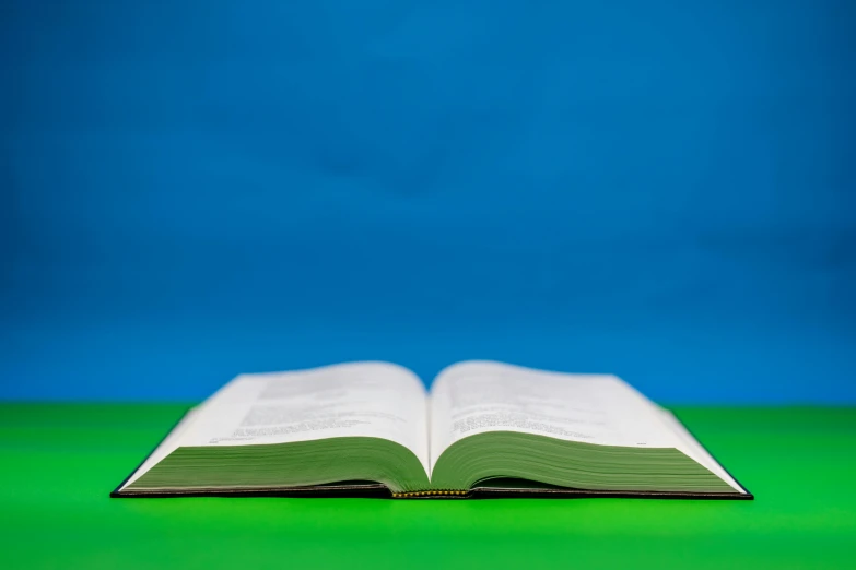 an open book sitting on top of a green counter