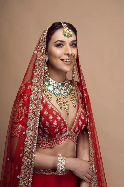 a woman wearing a red bridal with jewels on her shoulder