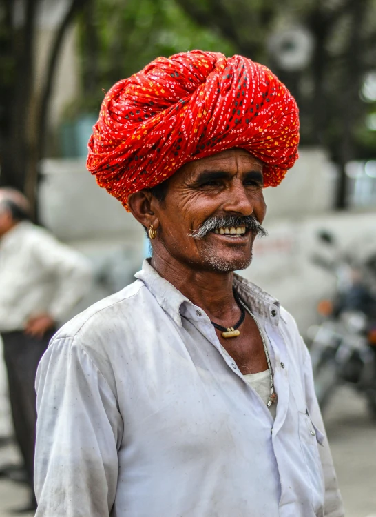 an older man with a very colorful red turban