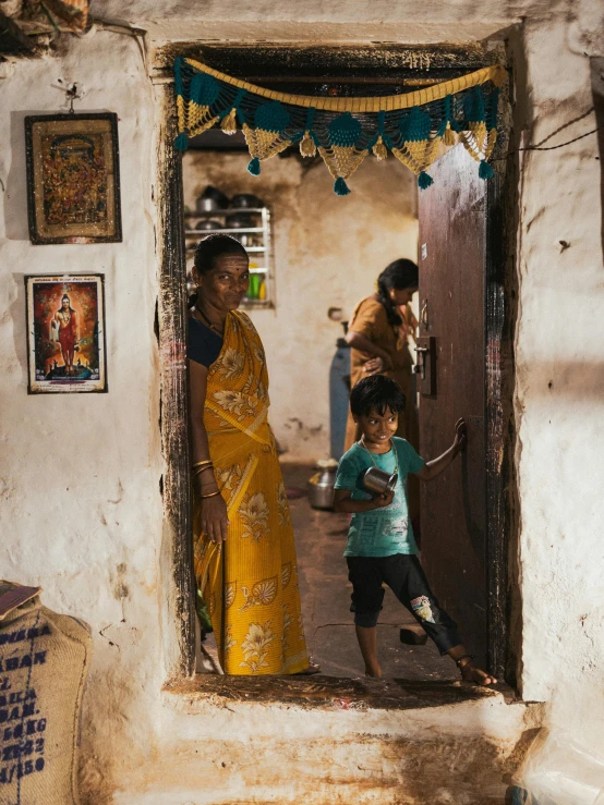 two women and a boy playing outside a door