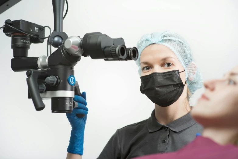 two people wearing masks and goggles looking at an electronic camera