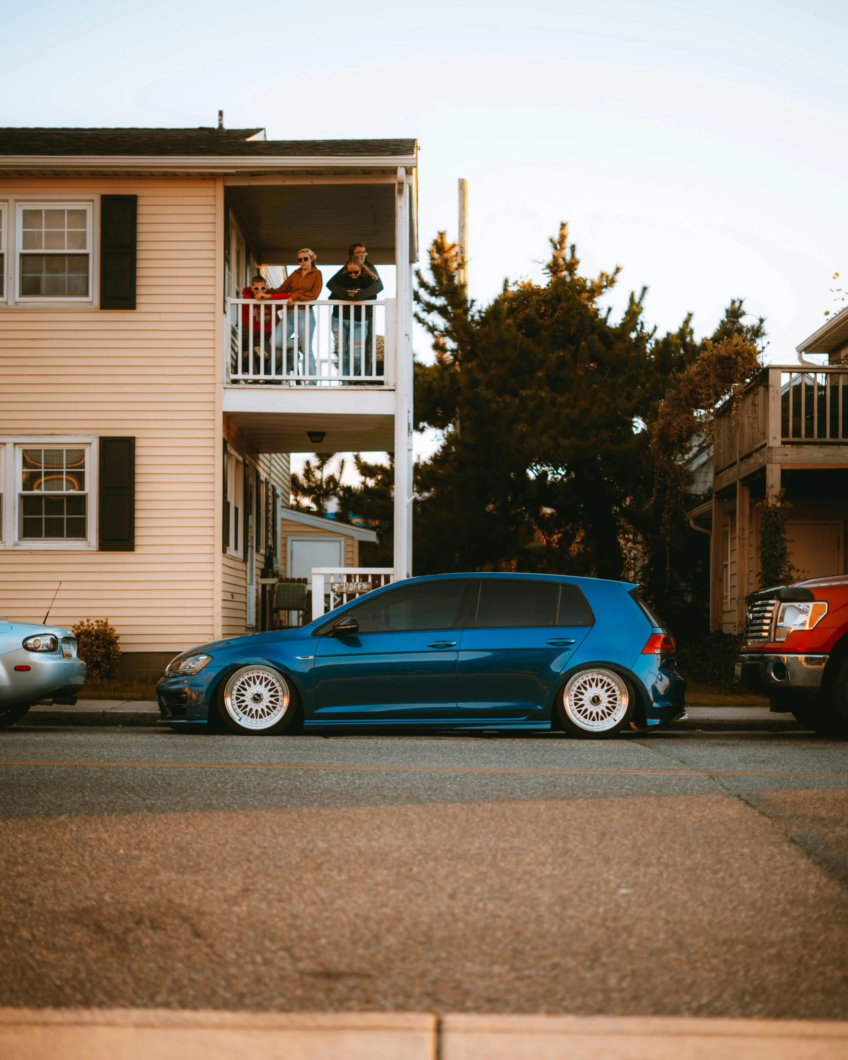 the blue car is parked in front of two large building