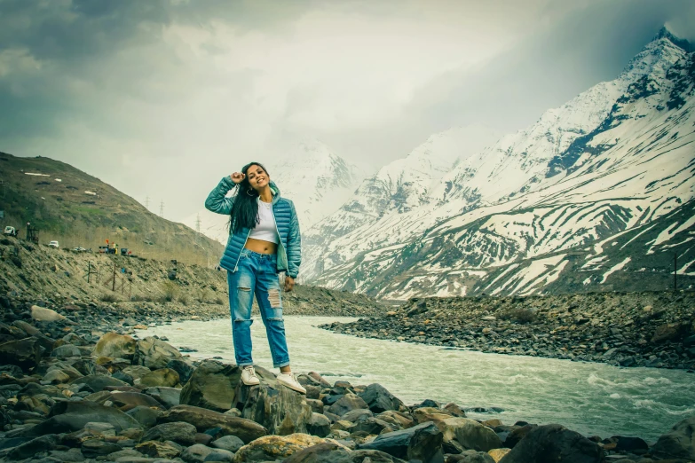 a woman poses in front of mountains while on the phone