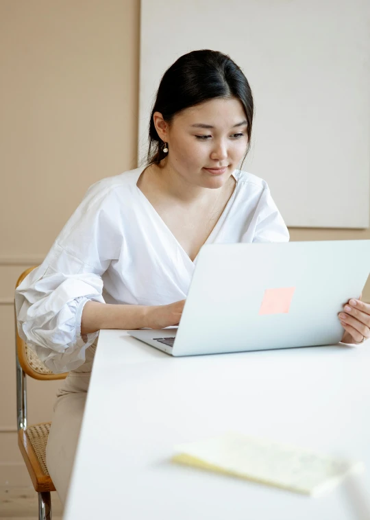 a person sitting at a table with a laptop