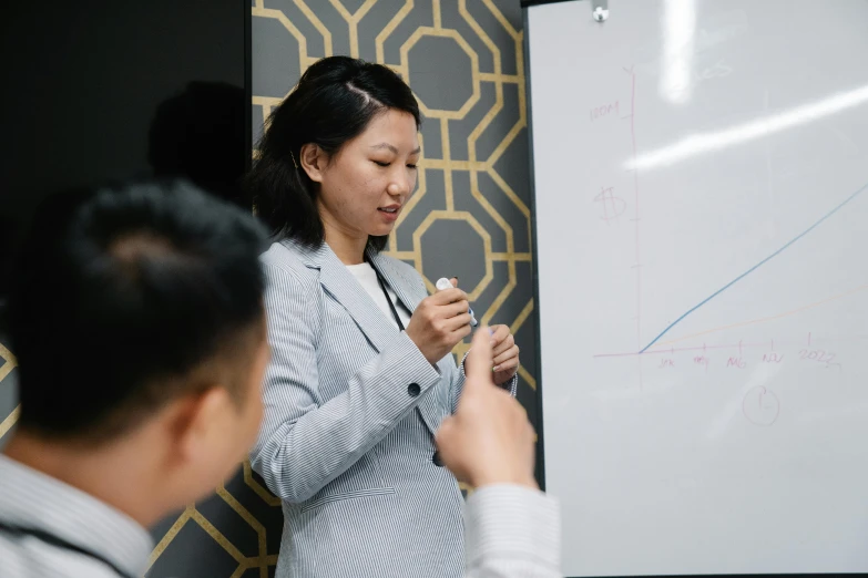 asian couple holding up cell phone at meeting