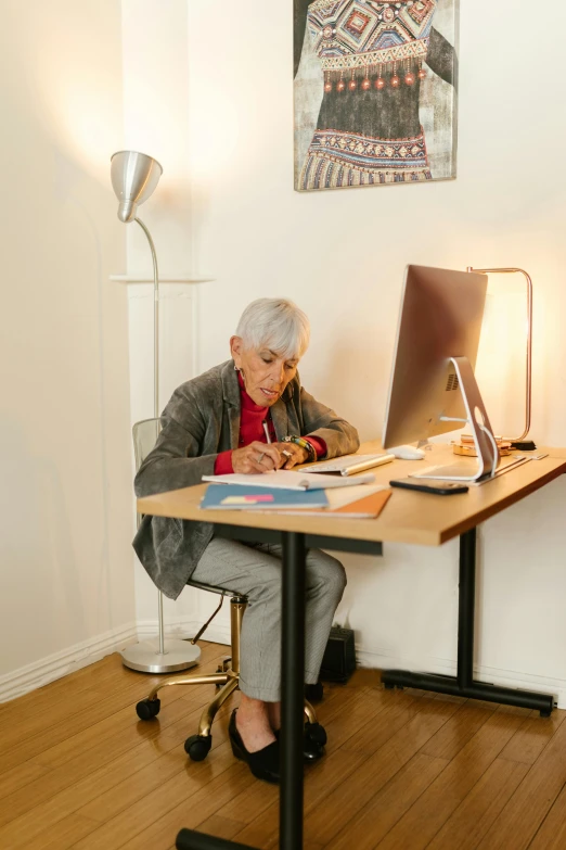 a man writing on his computer while sitting at a table