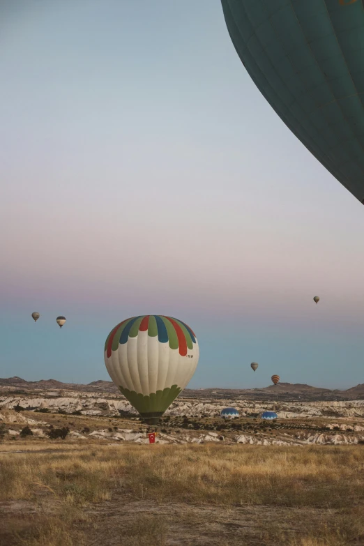 colorful balloons flying in the sky next to an open field